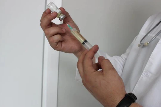 Врач набирает лекарство из флакона